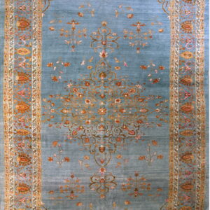 Azure rug with visible sheen, detailed floral motifs in gold, rust, and pink, surrounded by a wide border.