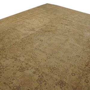 Monochromatic tan rug with a faintly visible traditional floral pattern and low pile, shown against a white background.