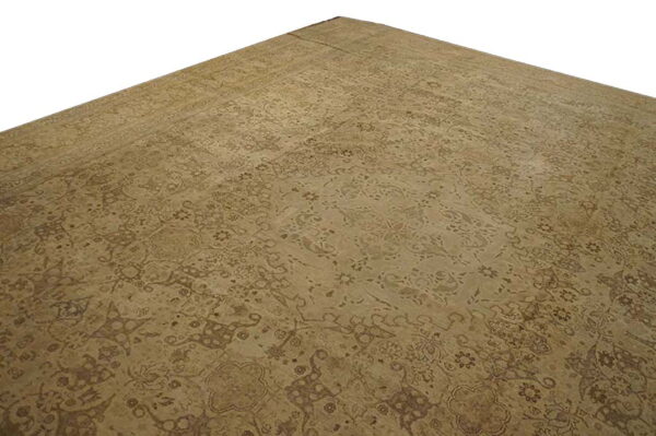 Monochromatic tan rug with a faintly visible traditional floral pattern and low pile, shown against a white background.