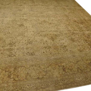 Muted khaki and brown traditional rug with an overall pattern and ornate border shown against a white background.