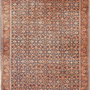 Ornate area rug with a dark blue field and intricate all-over floral patterns in orange and beige.