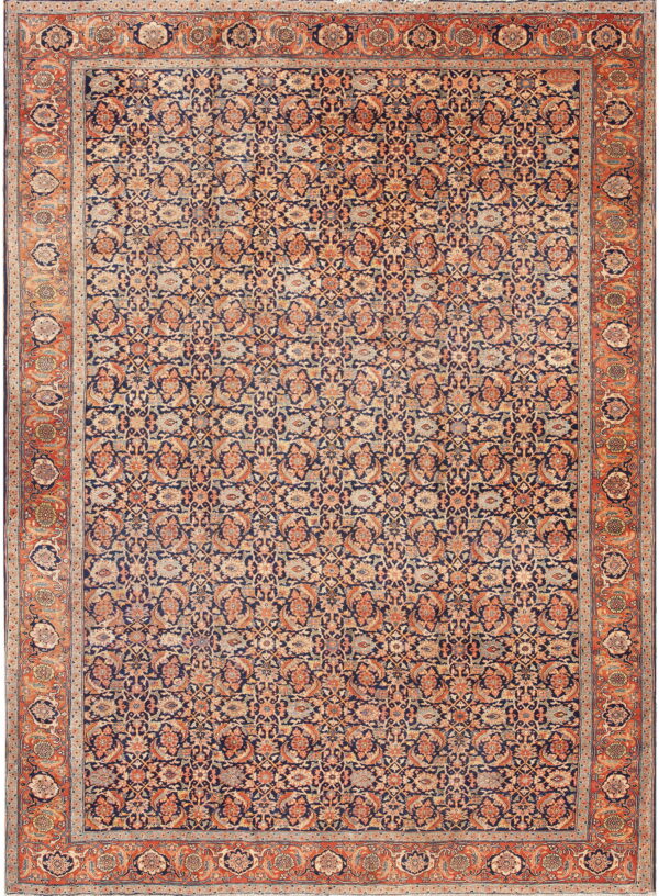 Ornate area rug with a dark blue field and intricate all-over floral patterns in orange and beige.