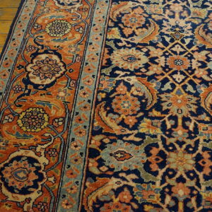A navy and orange traditional rug with intricate floral motifs is partially visible on hardwood.