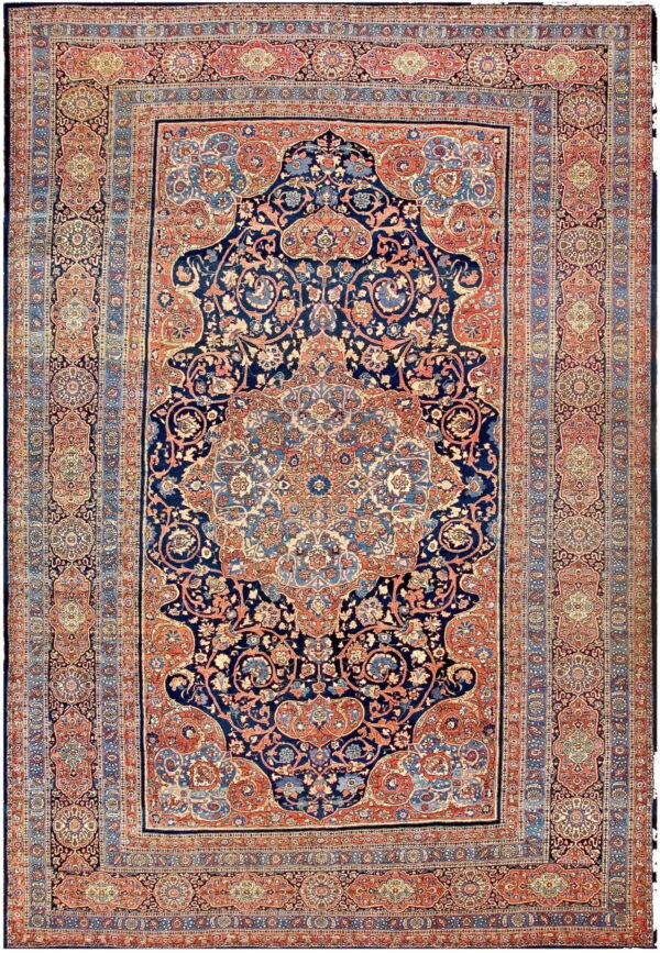 Navy blue area rug with an intricate medallion and floral pattern bordered in rust and light blue.