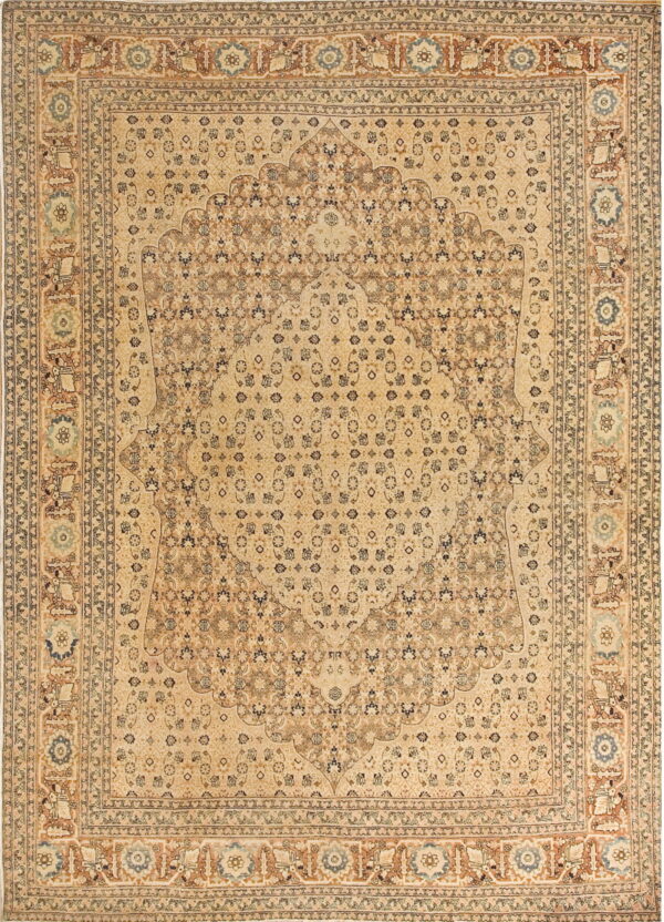 Beige traditional area rug featuring a large central medallion and intricate brown and blue floral patterns.