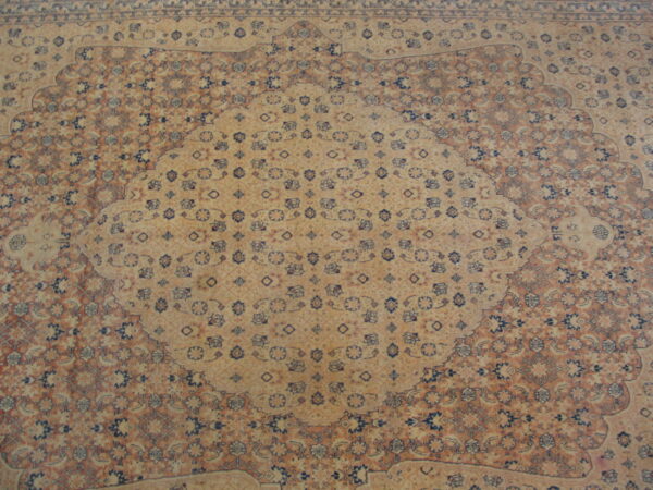 Ornate traditional rug with a large beige medallion framed by rust and navy floral motifs.