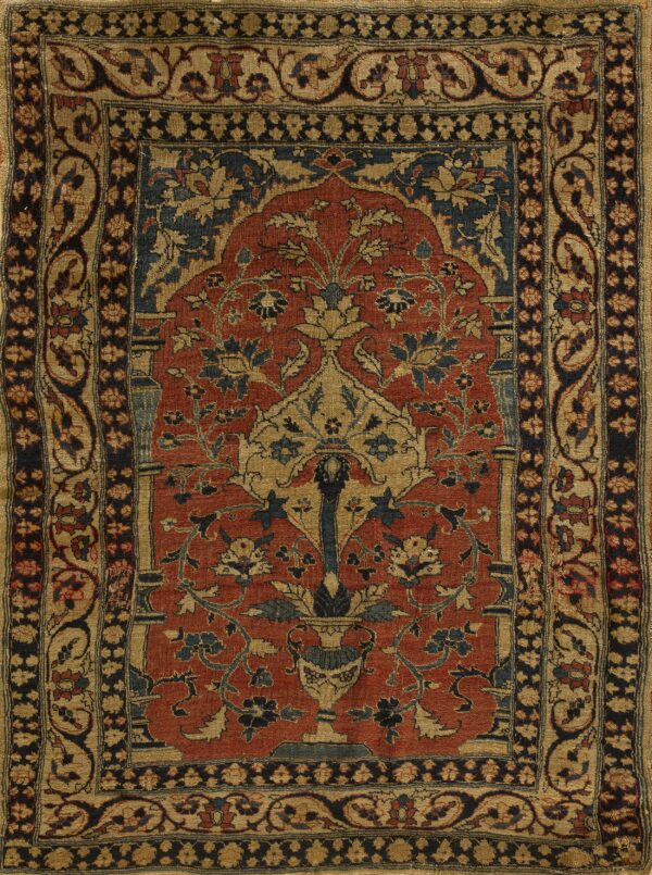 Red and tan rug with a central arched floral design, navy accents, and complex geometric borders.