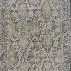 A large, traditionally patterned rug featuring distressed sage green, tan, and gold colors in an intricate repeating motif and paisley border.