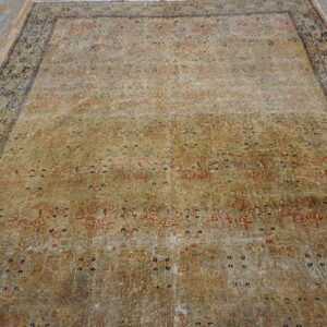 Washed gold and tan traditional rug with faded red designs, displayed on distressed gray wood planks.
