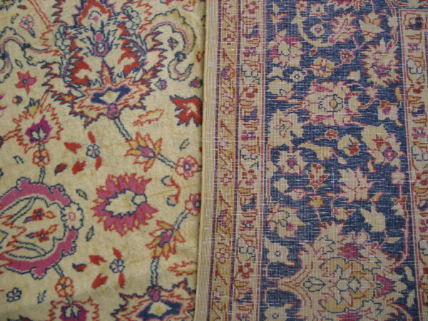 Two adjacent rug sections display contrasting cream and navy blue fields with red and pink floral patterns.