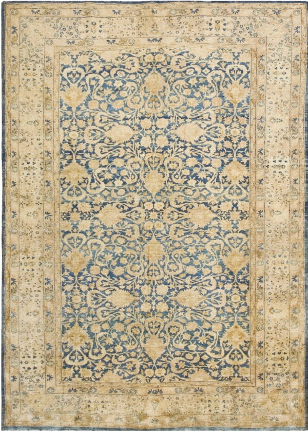 A traditional rug featuring a blue field with cream and gold floral motifs and wide tan borders.