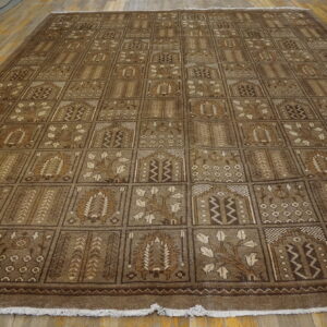 Low pile brown rug with an allover grid pattern of traditional motifs on wood floors.