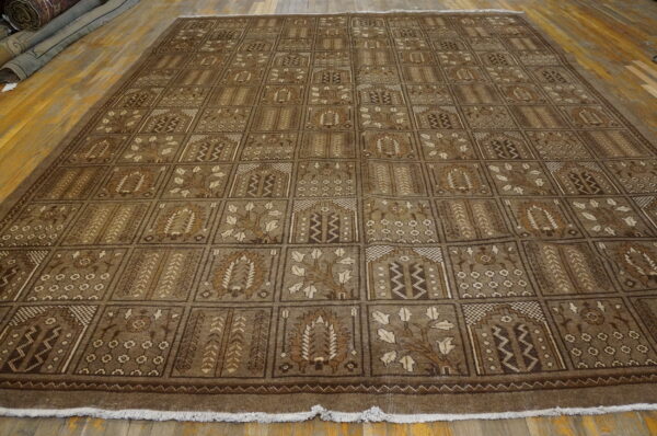 Low pile brown rug with an allover grid pattern of traditional motifs on wood floors.