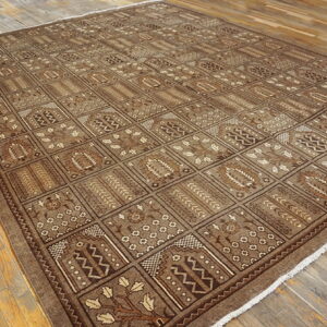 Monochromatic brown rug featuring a geometric repeating grid and stylized floral designs on distressed wood floors.