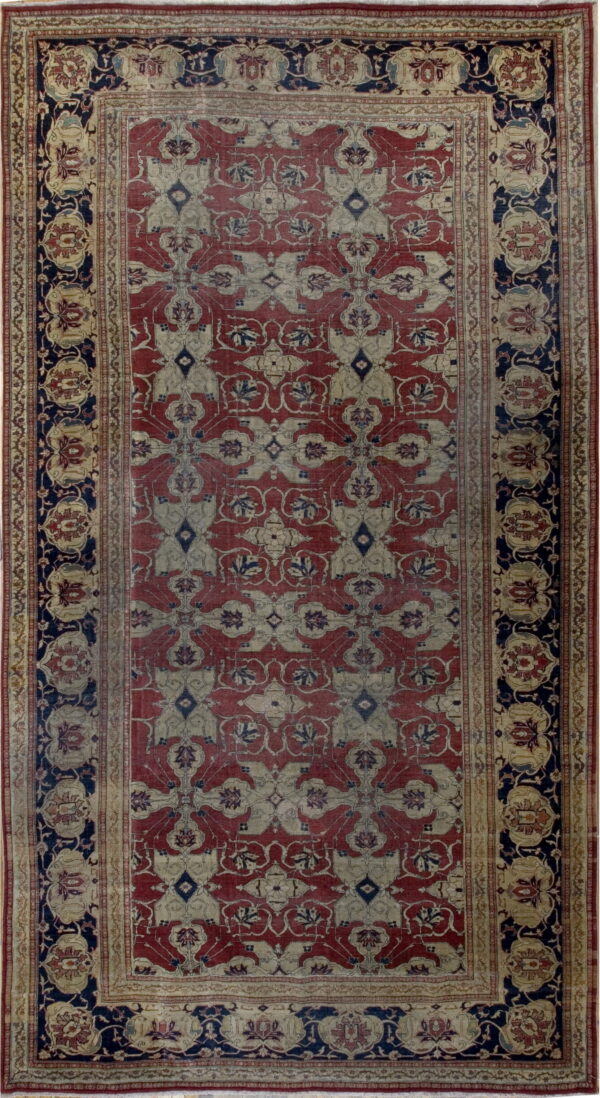 Low-pile traditional rug featuring faded red, beige, and navy interlocking floral patterns.
