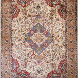 Intricate patterned rug with an ivory field, large blue medallion, red corners, and a wide sienna border.
