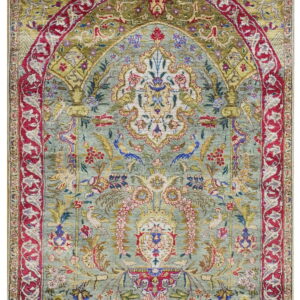 A detailed low pile rug with a light aqua field, red border, and ornate floral mihrab design.
