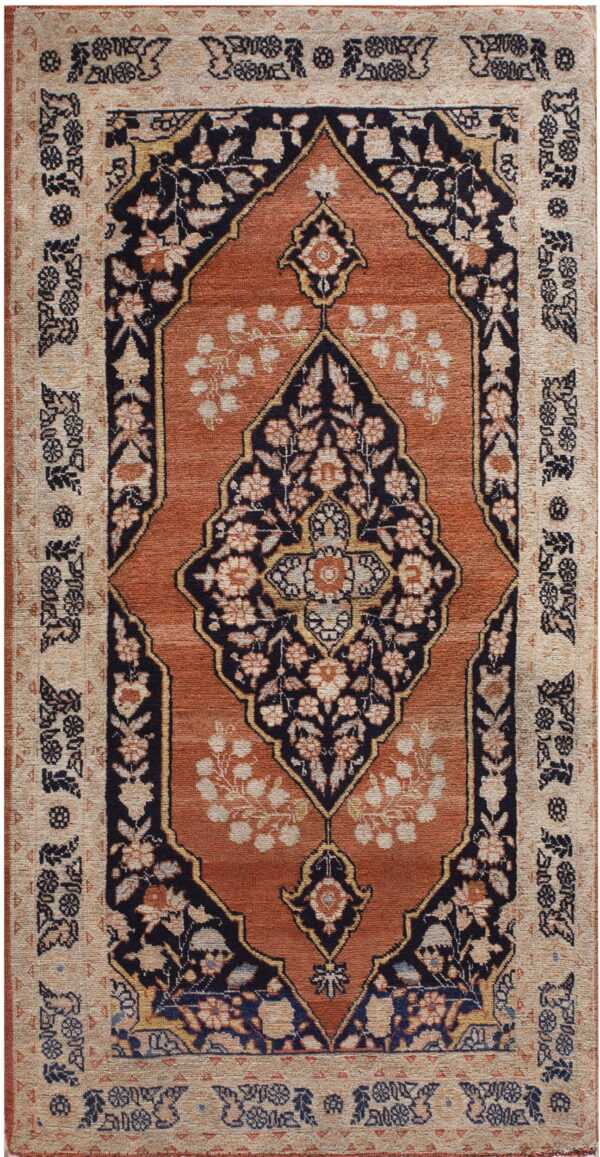 Low-pile rug with a navy floral medallion on a terracotta field and a densely patterned beige border.