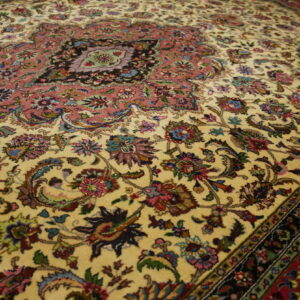 Traditional rug featuring a central rose medallion and intricate multicolored floral details on a cream field.