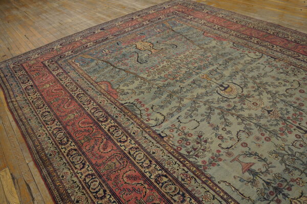 Muted teal rug with a detailed floral pattern and multi-layered terracotta and blue-black borders on wood floor.