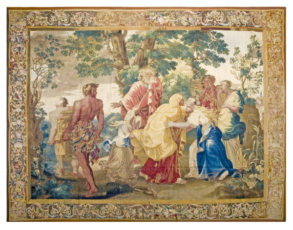 Woven tapestry with an elaborate floral and scrolling border framing a narrative scene of figures and trees.