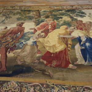 Low-pile rug displays a classical figurative scene in blue, red, and gold, bordered by florals, on wood.