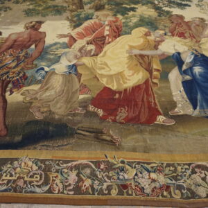 Figurative tapestry-style rug depicts figures in red and blue robes, framed by a detailed floral border on the floor.