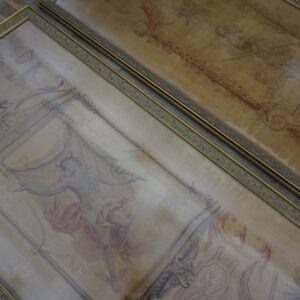 Two ornate, framed low-pile rugs display faded classical figures and scrolling patterns on dark wood flooring.