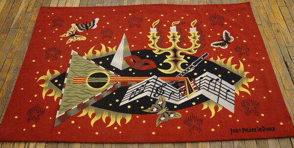 Red rug displaying a colorful abstract design of music notes, candelabra, and butterflies on wooden floorboards.