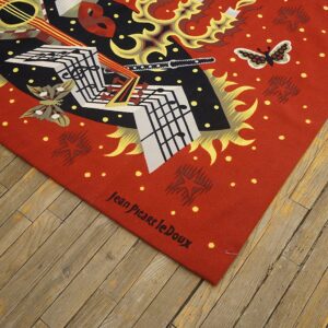 Flat weave rug in red, black, and white features abstract music and butterfly art on a wood floor.