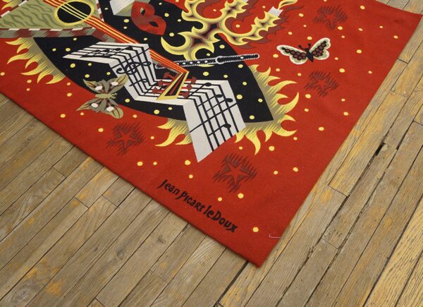 Flat weave rug in red, black, and white features abstract music and butterfly art on a wood floor.