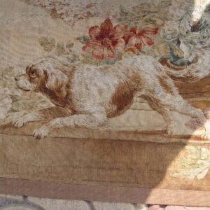 Low-pile rug with a detailed tapestry design of a brown dog and red, pink, and blue florals.