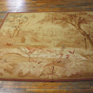 Square, low-pile rug in sepia tones depicts a nature scene with wading birds and tall trees on wood flooring.