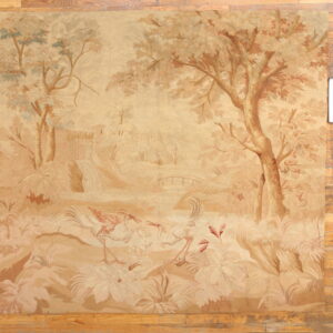 Tan and beige low-pile scenic rug featuring a pastoral landscape with trees and large wading birds on wood flooring.