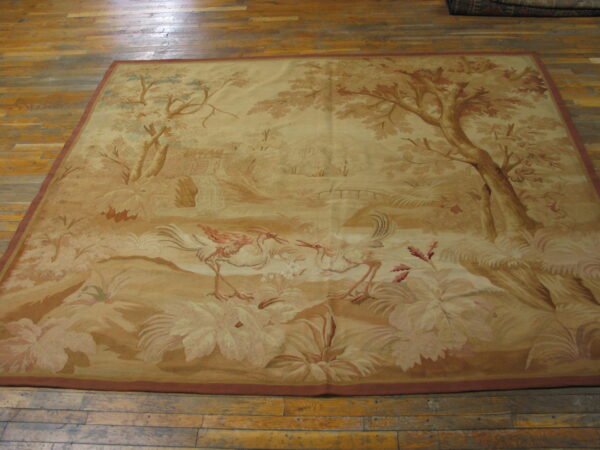 Beige pictorial rug depicting trees, a waterfall, and two large wading birds on wood flooring.