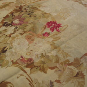 Low-pile rug detail showing muted beige and tan leaves surrounding bright magenta and pink floral motifs.