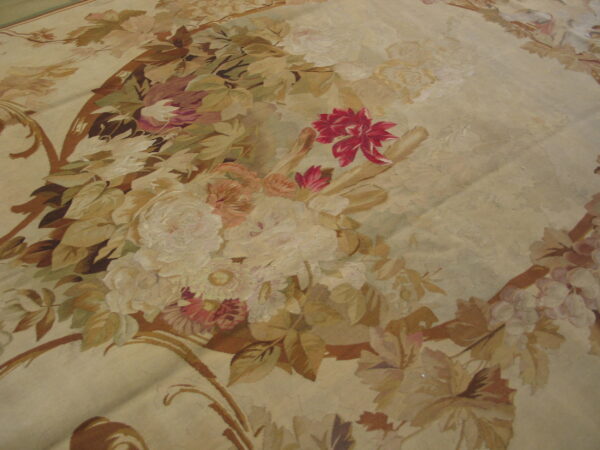 Low-pile rug detail showing muted beige and tan leaves surrounding bright magenta and pink floral motifs.