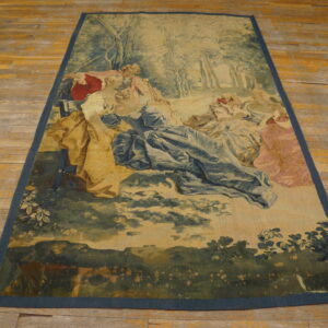 Low-pile tapestry rug depicting a pastoral scene in muted blues, greens, and pinks on a wood floor.