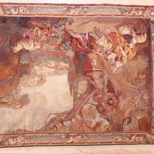 Muted, flatwoven rug with a detailed figural tapestry pattern in warm colors, framed by a floral border.