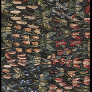 Woven detail of a rug with dense floral tapestry pattern in green, blue, rust, and cream colors.