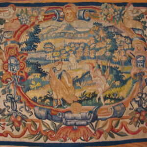 Flat-woven rug features a central pastoral scene surrounded by an ornate border with florals and stylized masks.