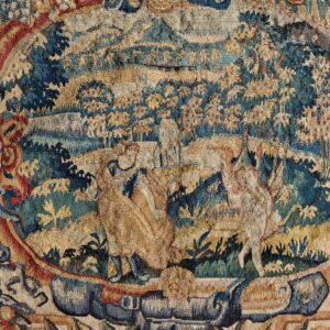 Muted tapestry textile displaying a central pastoral scene with two large animals surrounded by an ornate, figural border.