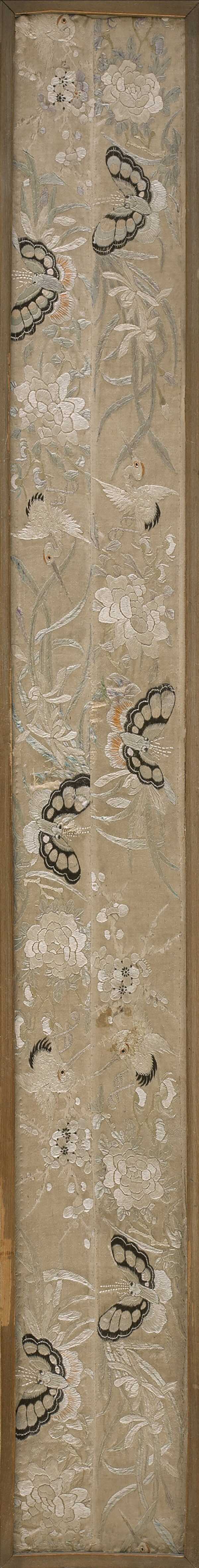 Embroidered beige textile runner featuring detailed white flowers, black butterflies, and birds, framed in wood.