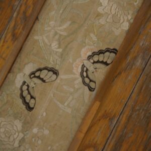 Low-pile beige runner with detailed white floral and butterfly patterns, bordered by distressed rustic wood floorboards.