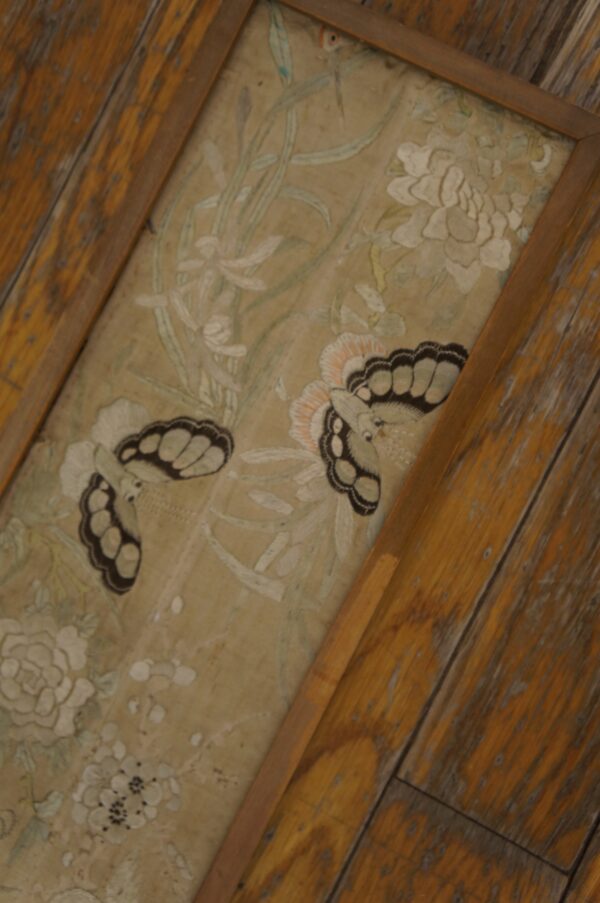 Low-pile beige runner with detailed white floral and butterfly patterns, bordered by distressed rustic wood floorboards.