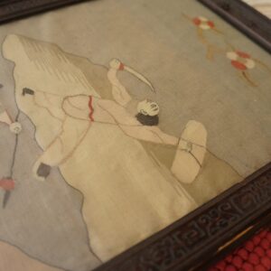 High-texture braided rug with stripes of red, cream, and brown visible beneath a framed picture.