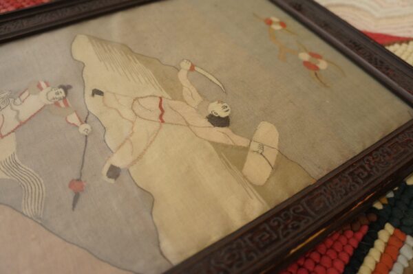 High-texture braided rug with stripes of red, cream, and brown visible beneath a framed picture.