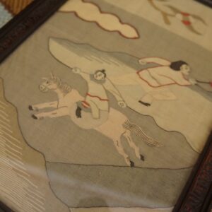 A multicolored striped shag rug in red, cream, blue, and tan is visible beneath a framed picture.