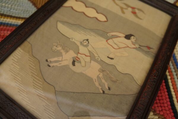 A multicolored striped shag rug in red, cream, blue, and tan is visible beneath a framed picture.