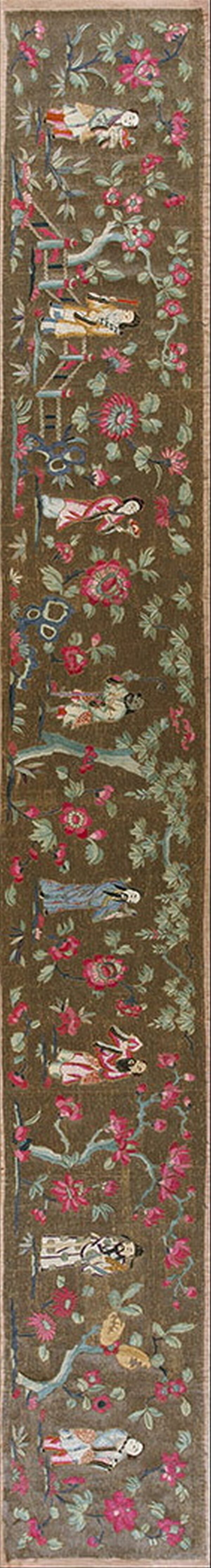 Dark brown runner rug with an intricate floral and figural design in pink, green, and blue.
